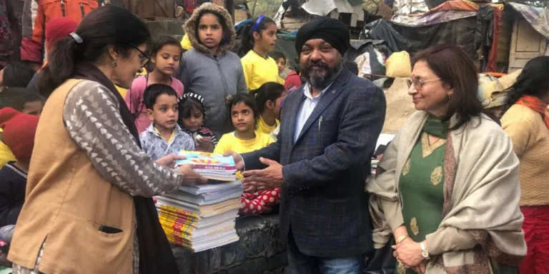 Books being distributed to students at a village school